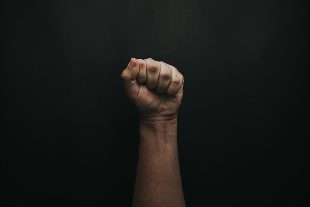 A powerful image of a raised fist against a dark background, symbolizing strength and unity.