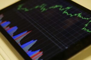Close-up of a tablet displaying stock market analysis with colorful graphs.