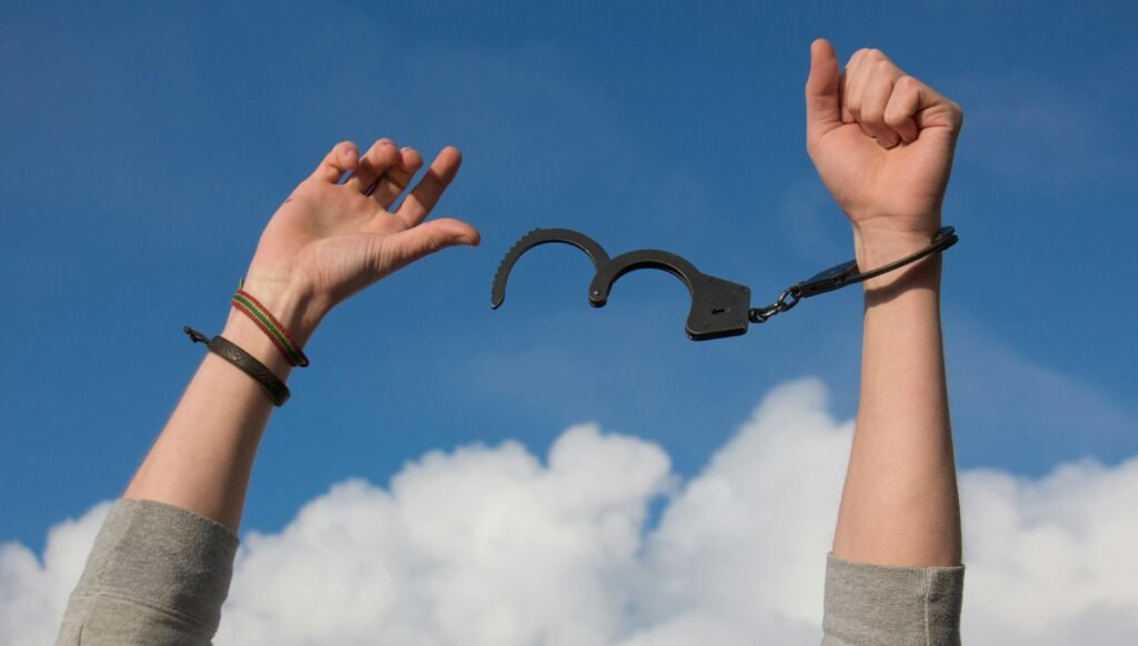 هنري برغسون والفعل الحر: الحرية بوصفها تعبيرًا عن الكيان الإنساني Symbolic image of freedom with open handcuffs against a bright blue sky.